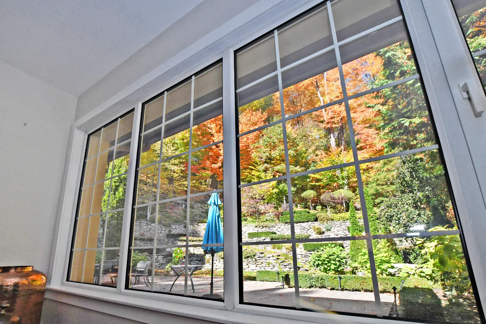 Interior of a house on Plymbridge Road in North York, with wood floors, a white kitchen, and windows onto the trees.