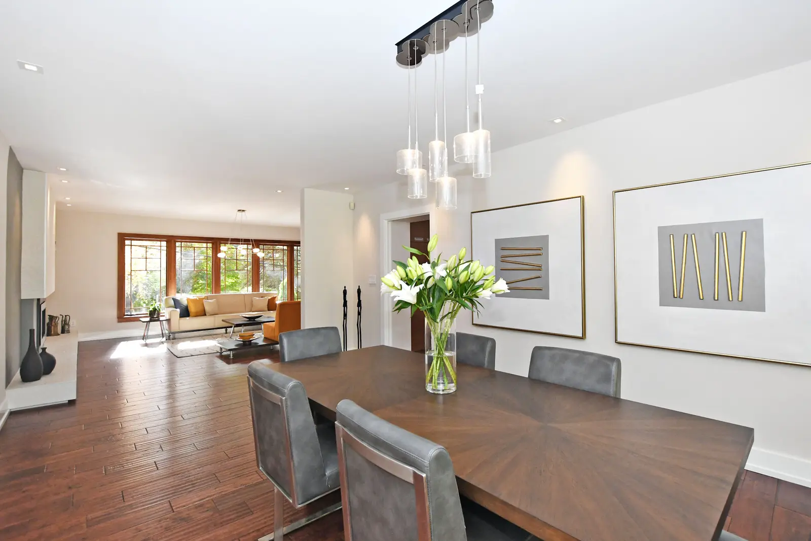 Interior of a house on Plymbridge Road in North York, with wood floors, a white kitchen, and windows onto the trees.