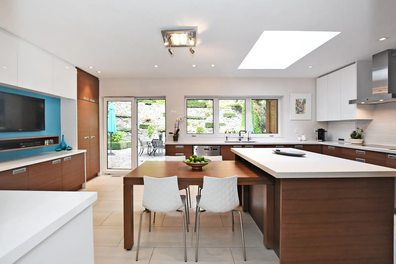 Interior of a house on Plymbridge Road in North York, with wood floors, a white kitchen, and windows onto the trees.
