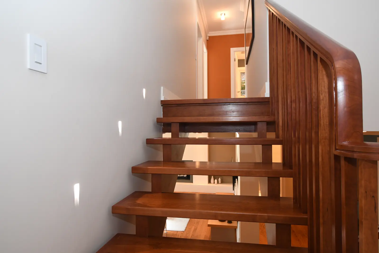 Interior of a house on Plymbridge Road in North York, with wood floors, a white kitchen, and windows onto the trees.