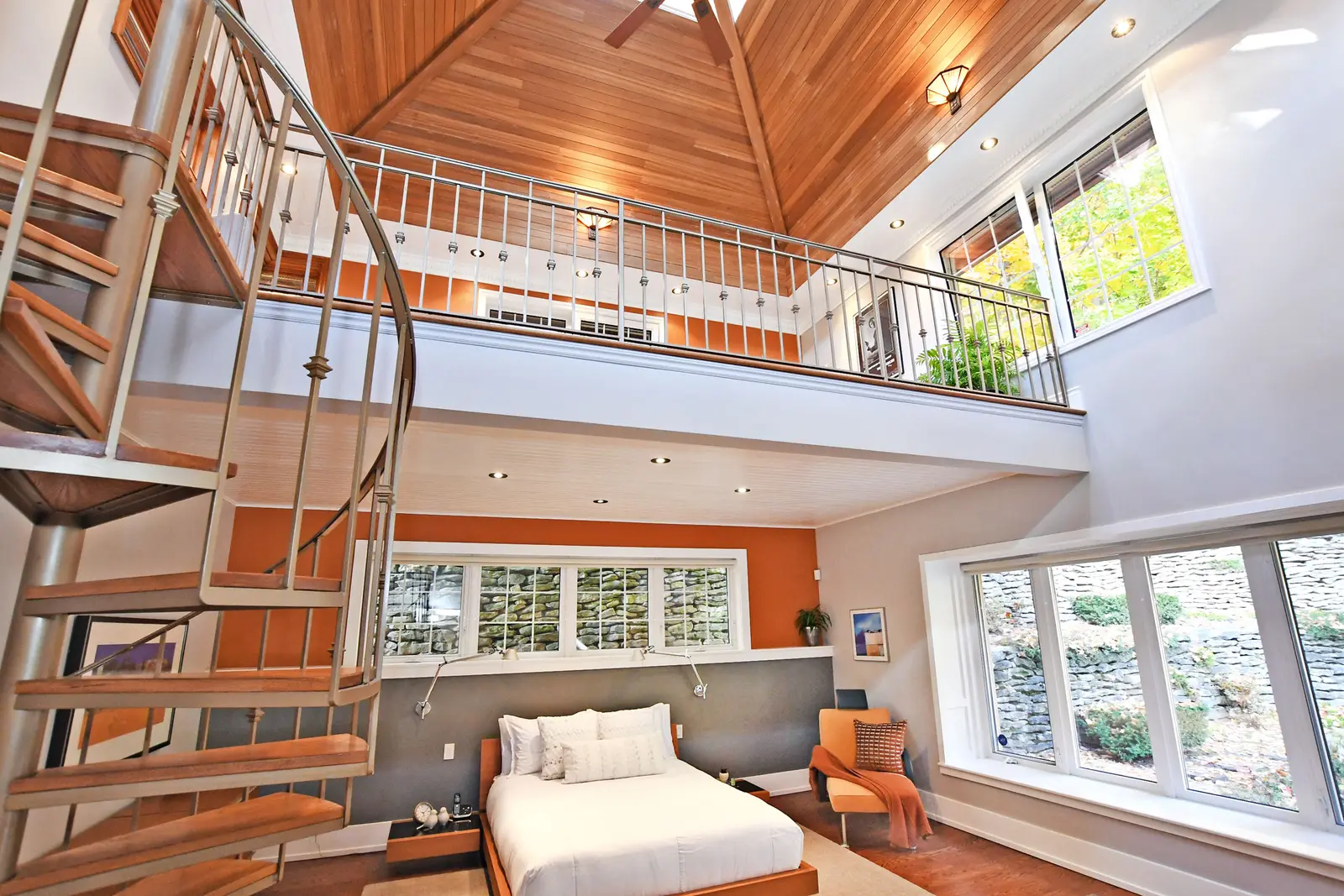 Interior of a house on Plymbridge Road in North York, with wood floors, a white kitchen, and windows onto the trees.
