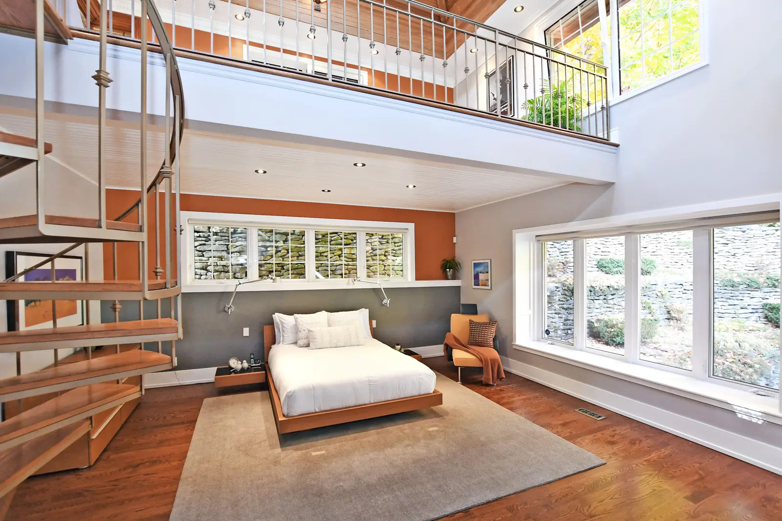 Interior of a house on Plymbridge Road in North York, with wood floors, a white kitchen, and windows onto the trees.