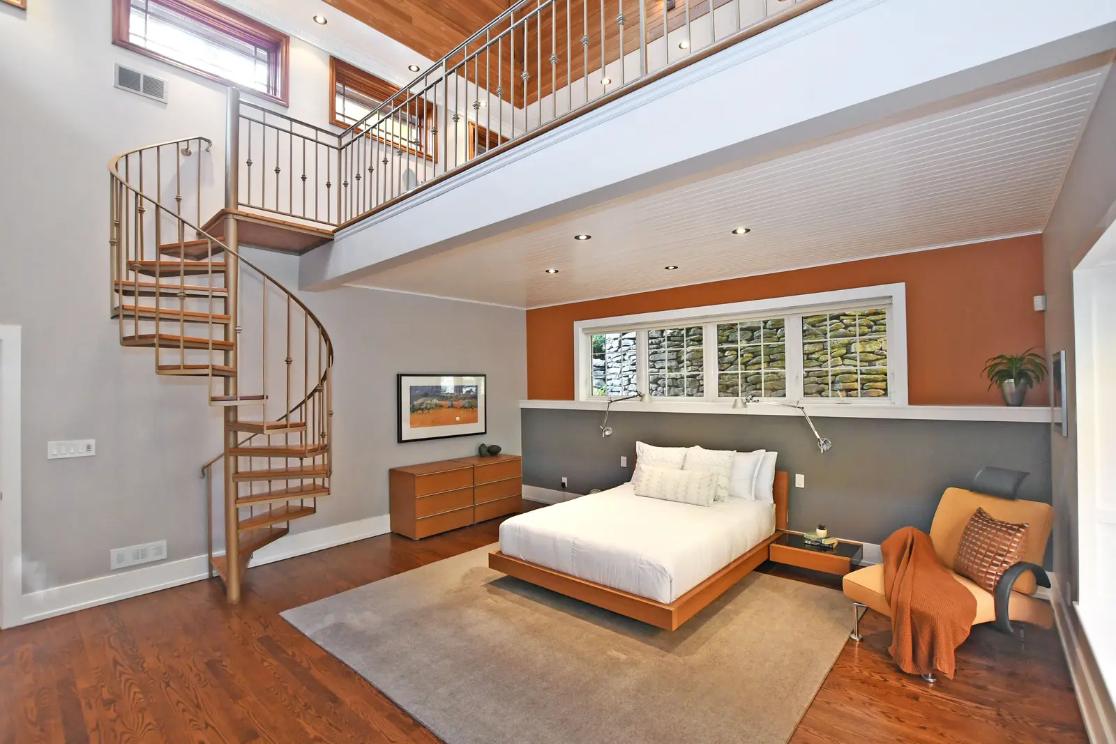 Interior of a house on Plymbridge Road in North York, with wood floors, a white kitchen, and windows onto the trees.