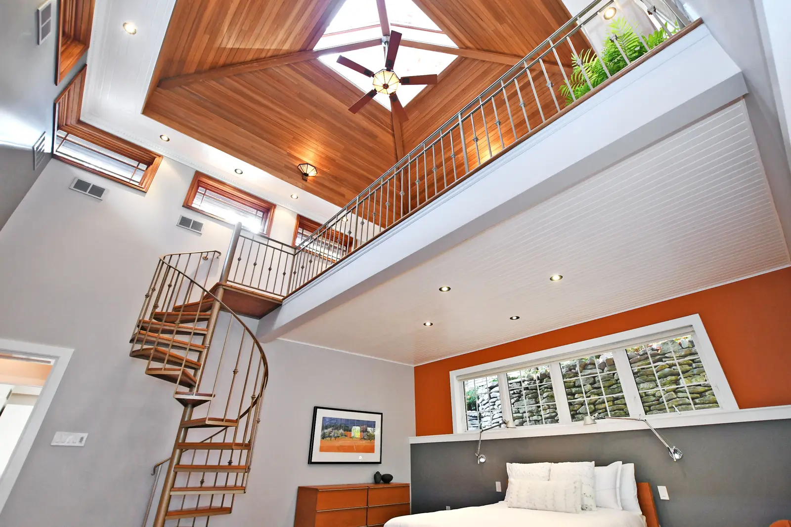 Interior of a house on Plymbridge Road in North York, with wood floors, a white kitchen, and windows onto the trees.