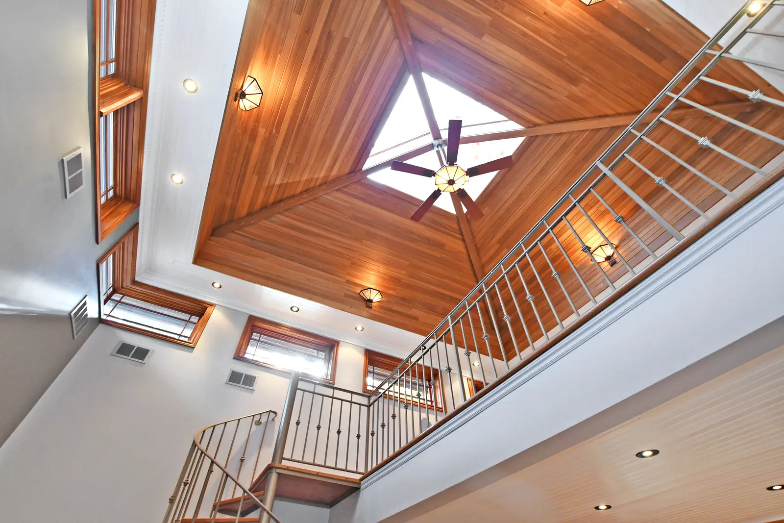 Interior of a house on Plymbridge Road in North York, with wood floors, a white kitchen, and windows onto the trees.