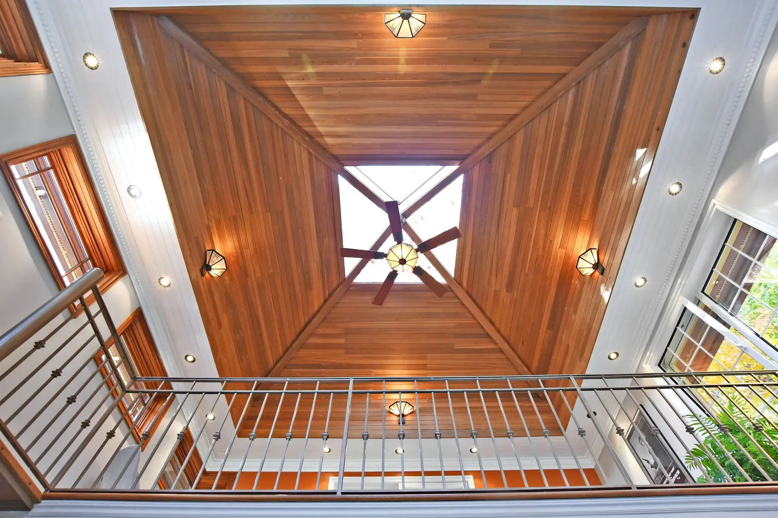 Interior of a house on Plymbridge Road in North York, with wood floors, a white kitchen, and windows onto the trees.
