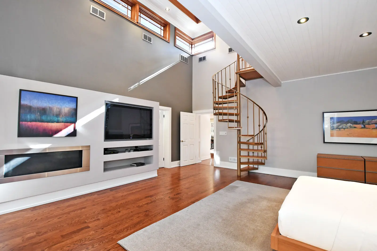 Interior of a house on Plymbridge Road in North York, with wood floors, a white kitchen, and windows onto the trees.