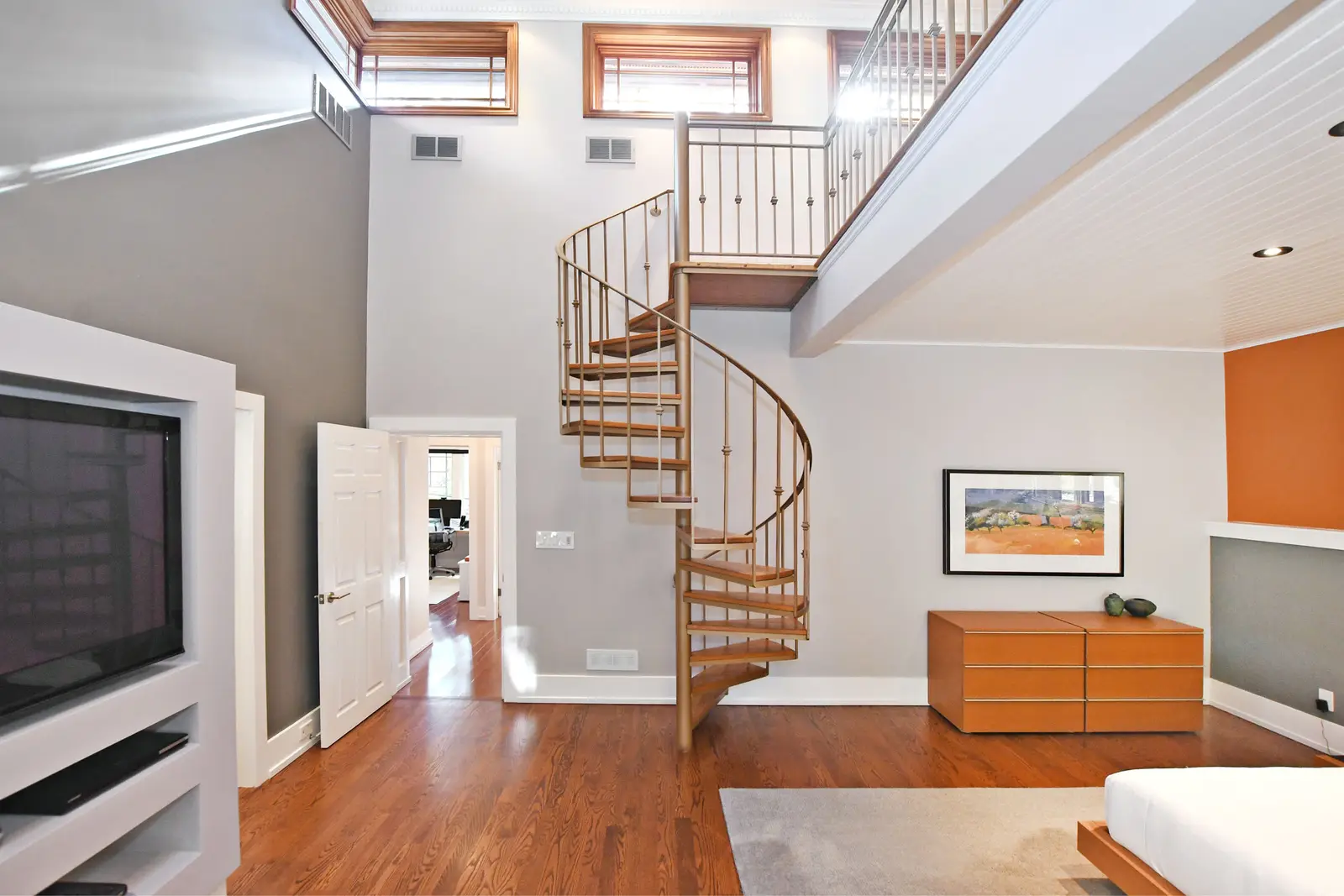 Interior of a house on Plymbridge Road in North York, with wood floors, a white kitchen, and windows onto the trees.