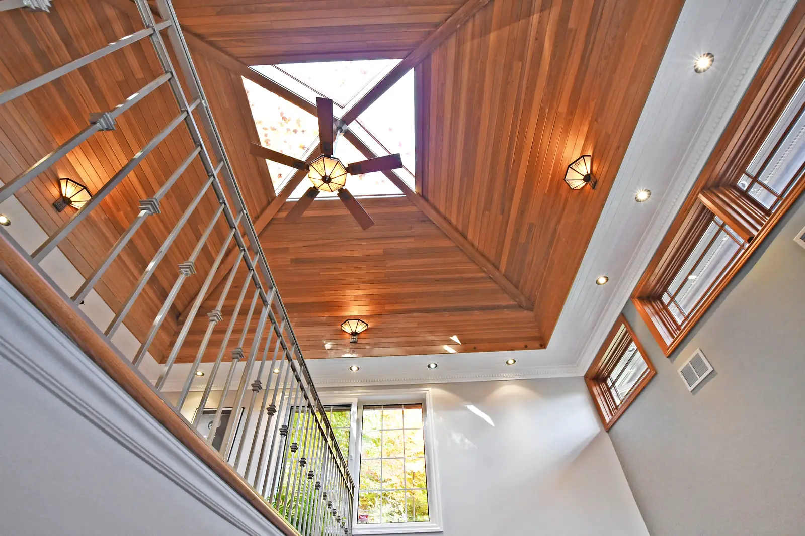 Interior of a house on Plymbridge Road in North York, with wood floors, a white kitchen, and windows onto the trees.