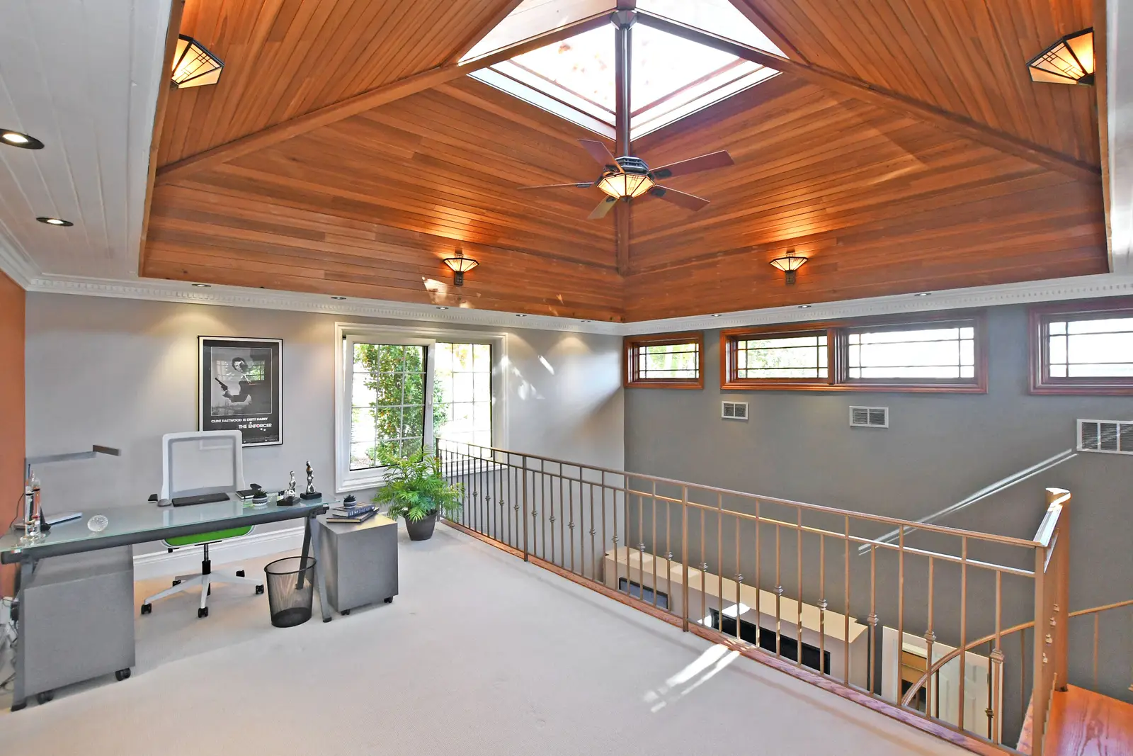 Interior of a house on Plymbridge Road in North York, with wood floors, a white kitchen, and windows onto the trees.