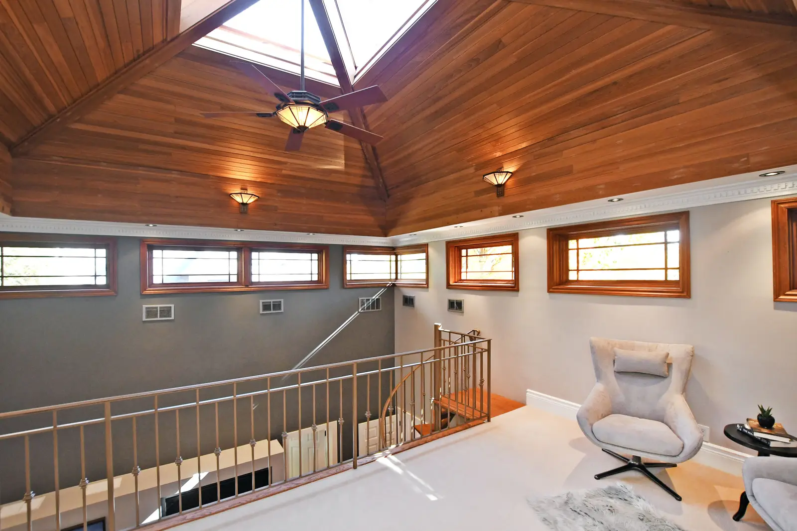 Interior of a house on Plymbridge Road in North York, with wood floors, a white kitchen, and windows onto the trees.