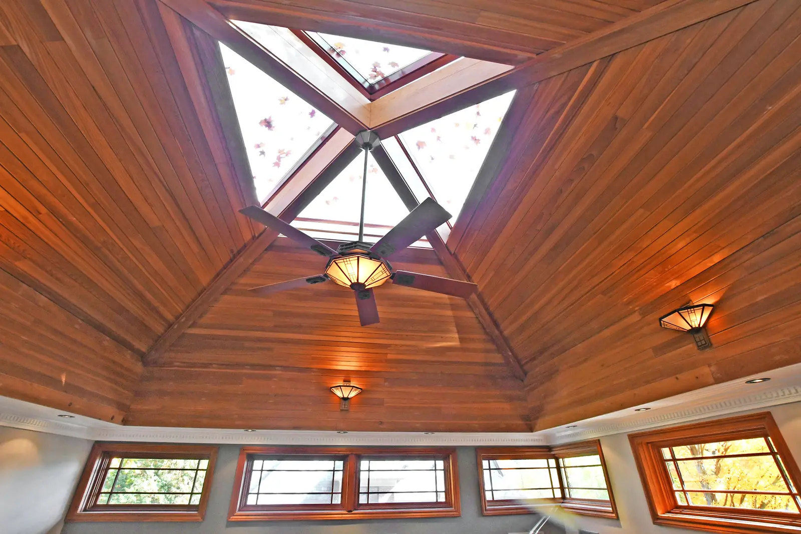 Interior of a house on Plymbridge Road in North York, with wood floors, a white kitchen, and windows onto the trees.