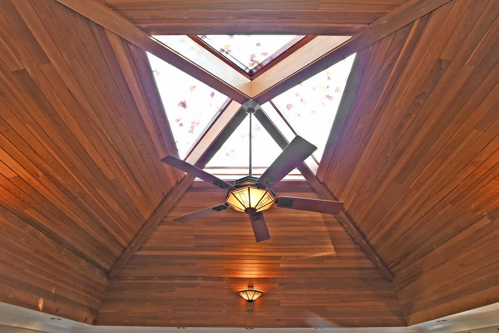 Interior of a house on Plymbridge Road in North York, with wood floors, a white kitchen, and windows onto the trees.