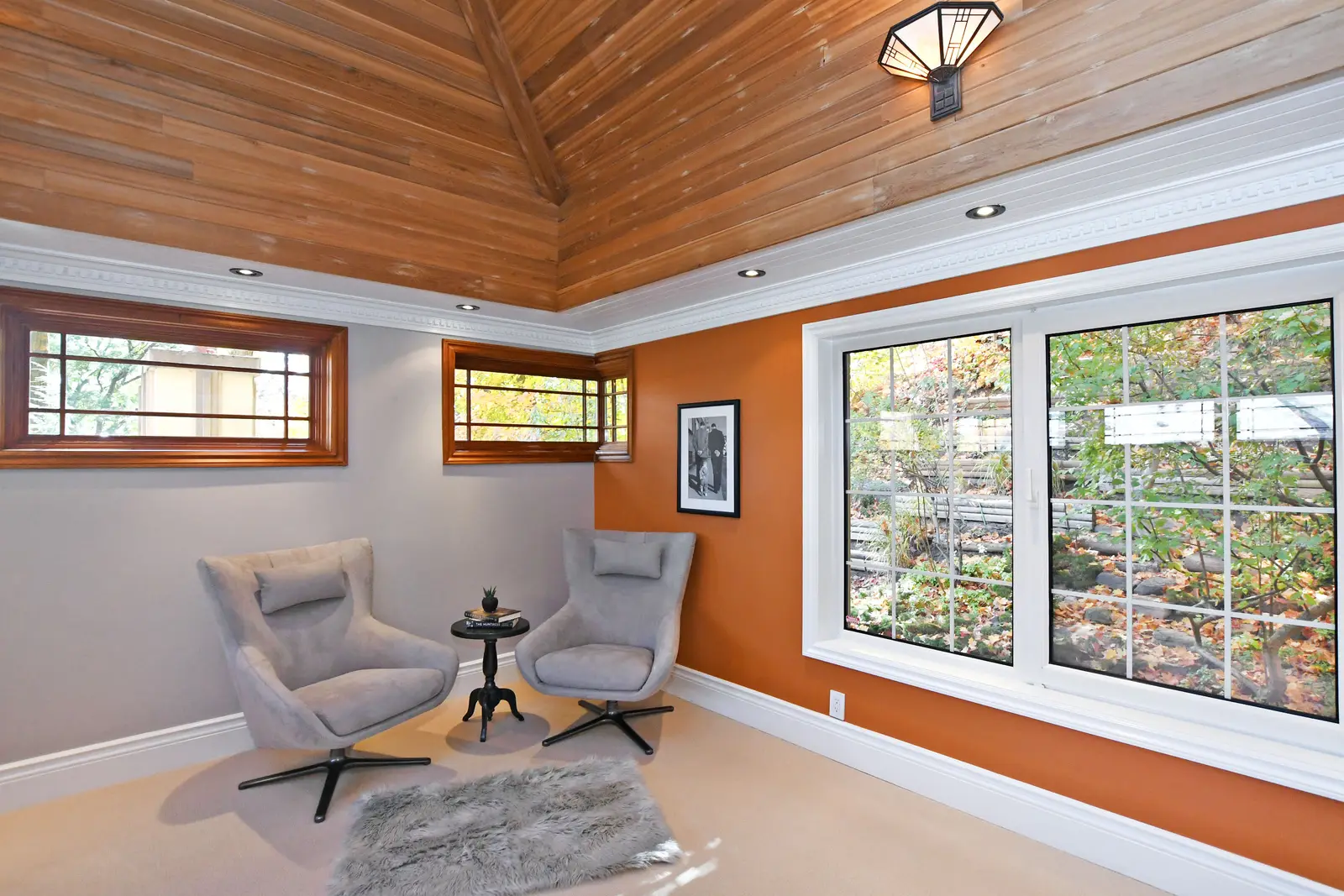 Interior of a house on Plymbridge Road in North York, with wood floors, a white kitchen, and windows onto the trees.