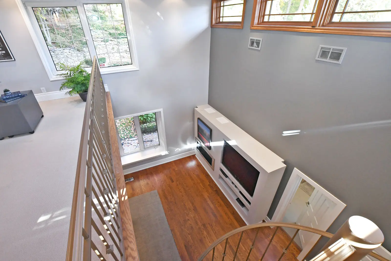 Interior of a house on Plymbridge Road in North York, with wood floors, a white kitchen, and windows onto the trees.