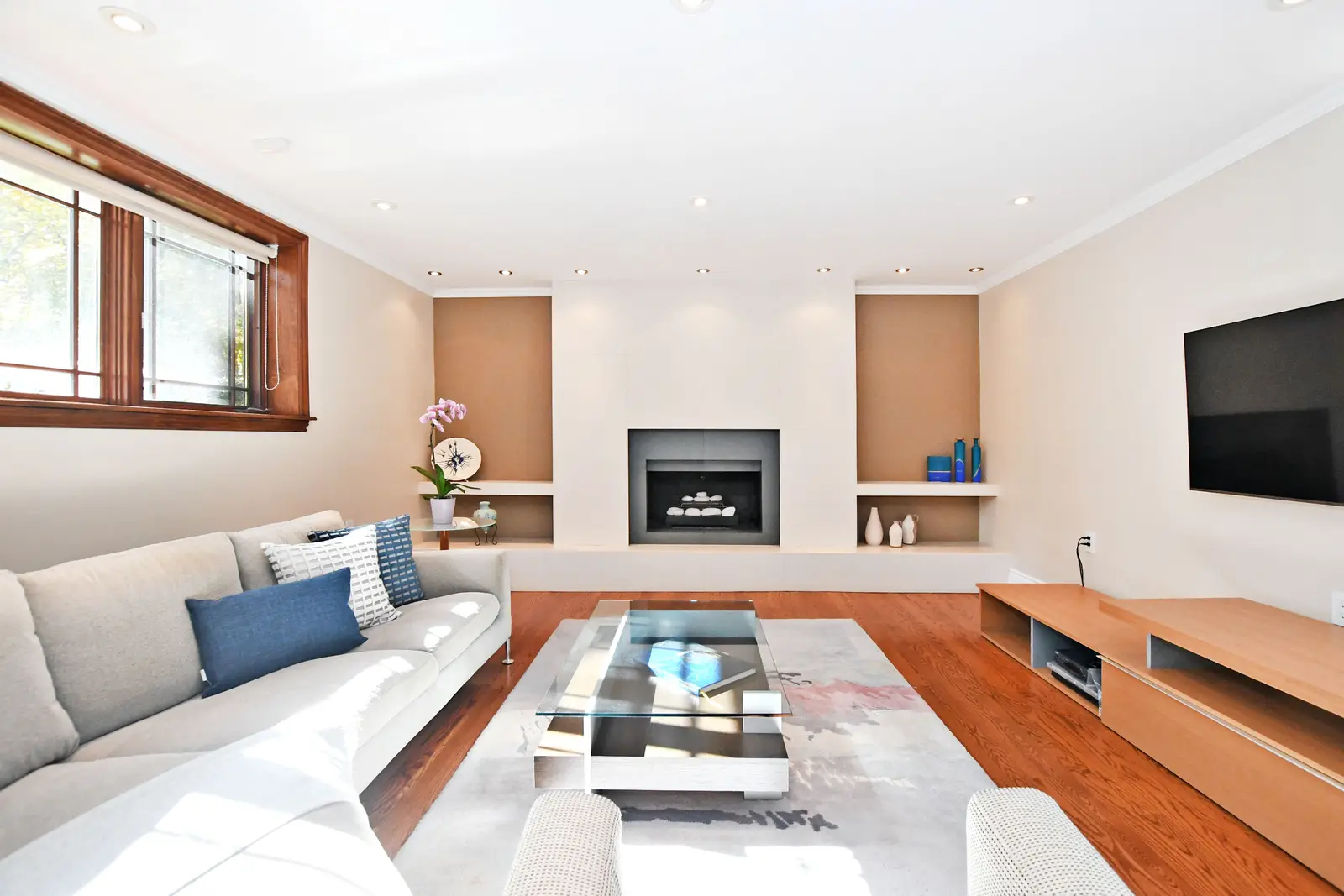 Interior of a house on Plymbridge Road in North York, with wood floors, a white kitchen, and windows onto the trees.