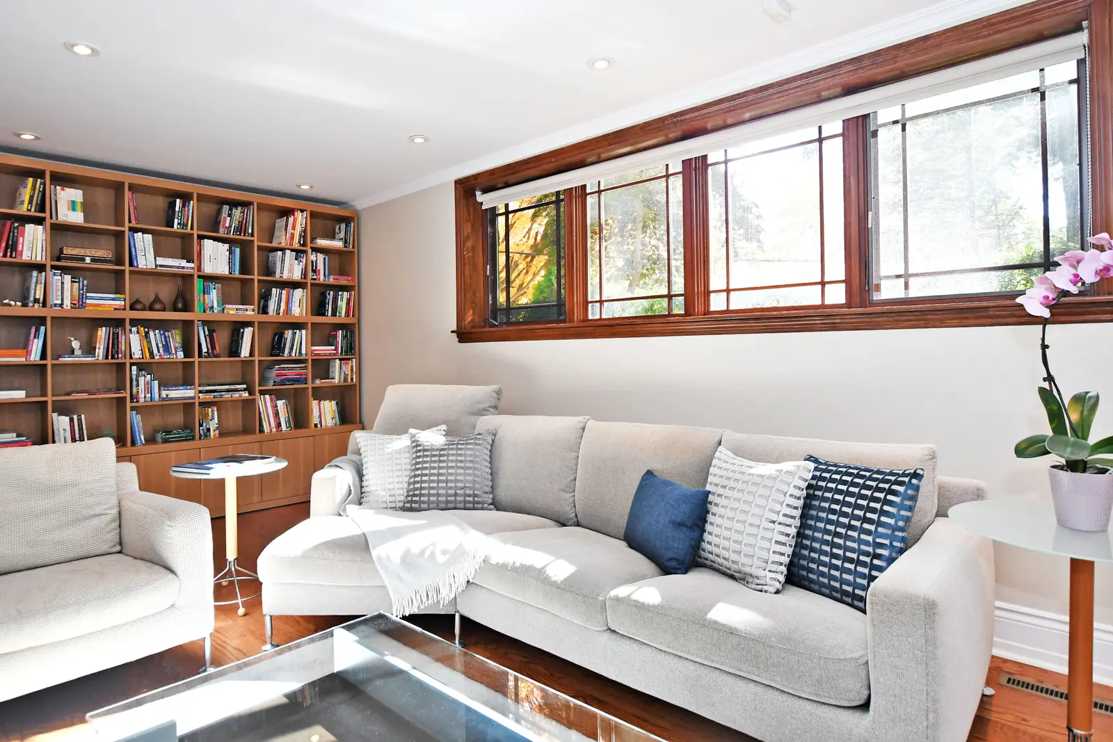 Interior of a house on Plymbridge Road in North York, with wood floors, a white kitchen, and windows onto the trees.