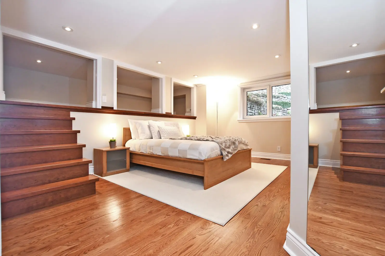 Interior of a house on Plymbridge Road in North York, with wood floors, a white kitchen, and windows onto the trees.