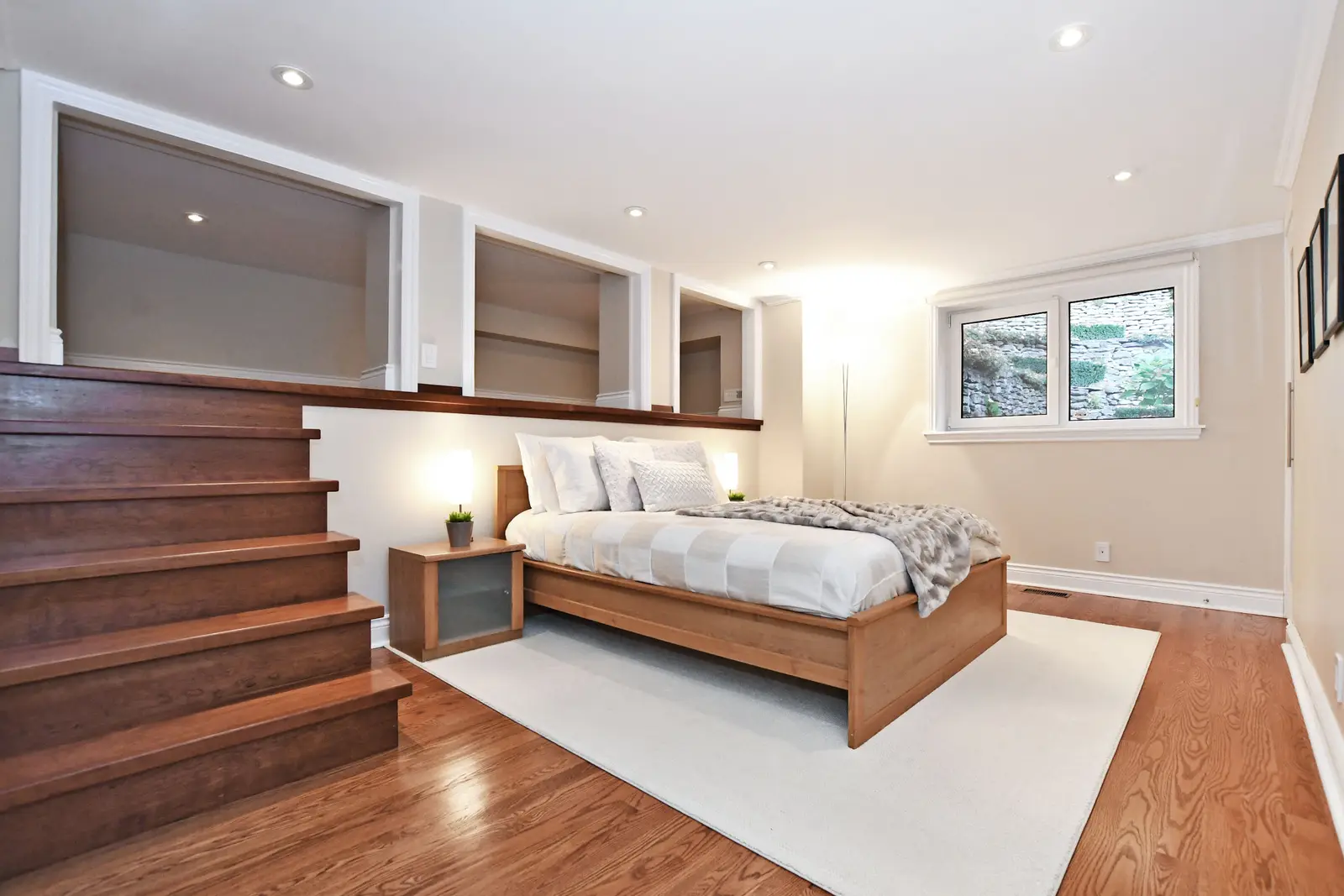 Interior of a house on Plymbridge Road in North York, with wood floors, a white kitchen, and windows onto the trees.