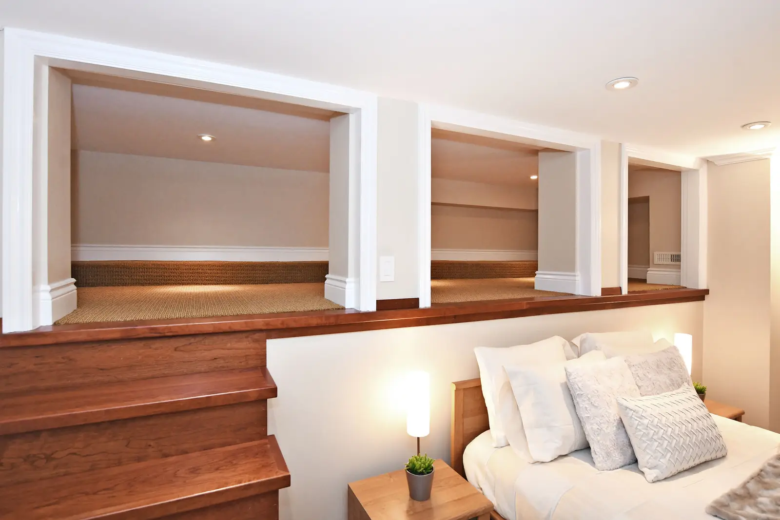 Interior of a house on Plymbridge Road in North York, with wood floors, a white kitchen, and windows onto the trees.