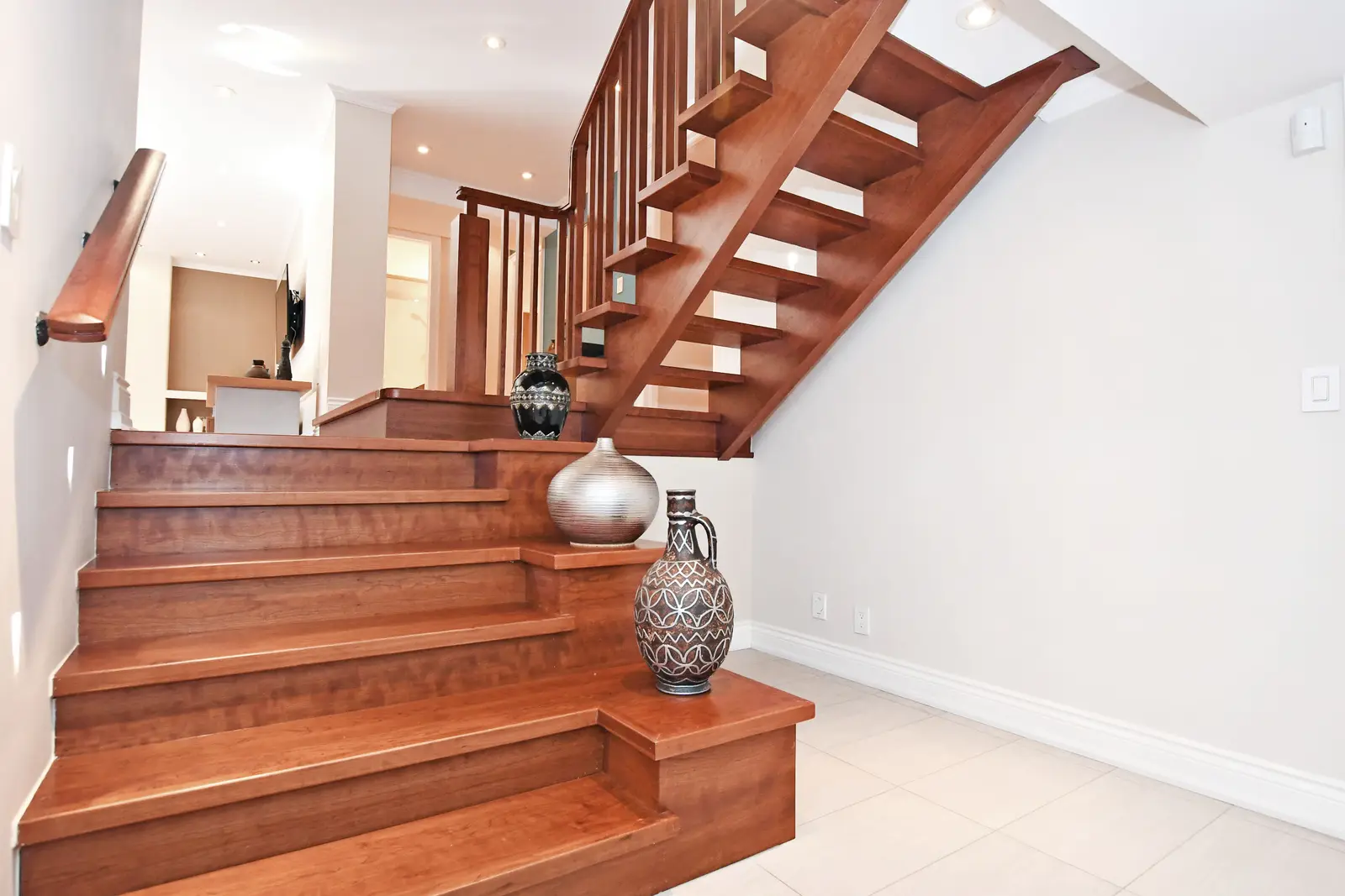 Interior of a house on Plymbridge Road in North York, with wood floors, a white kitchen, and windows onto the trees.